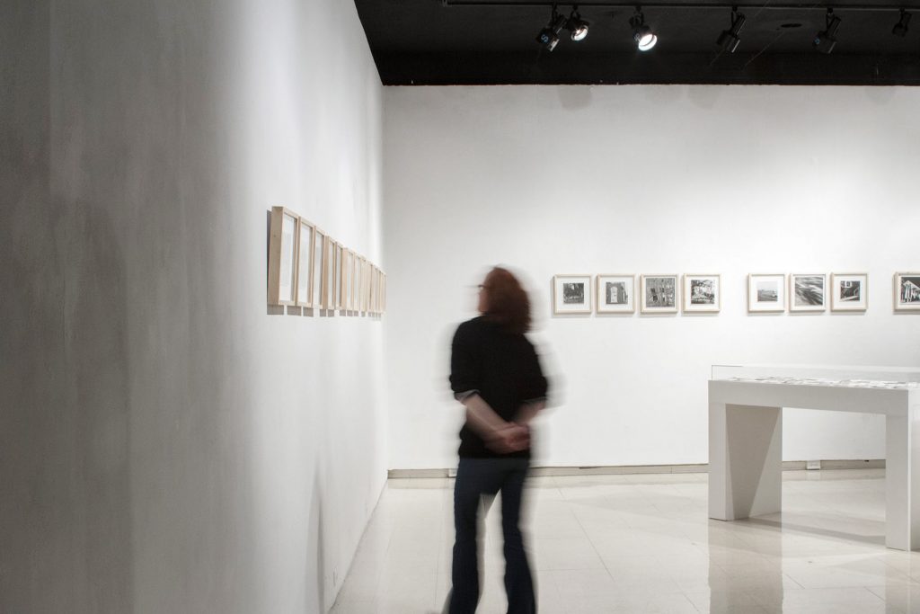 Installation View of photographs and gallery visitor